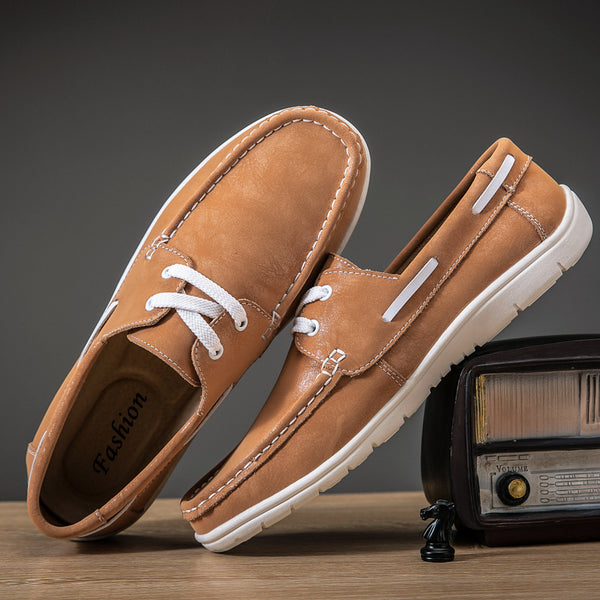 Brown leather shoes with white laces on a wooden surface with a vintage radio in the background.