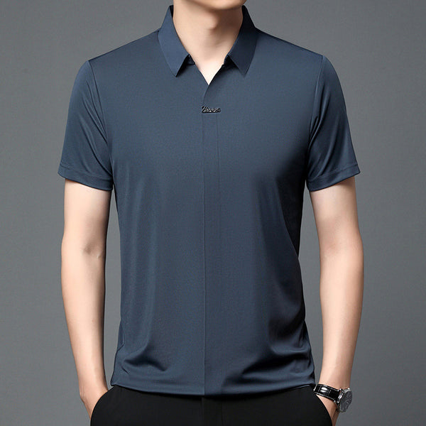 Man wearing a navy blue polo shirt on a gray background