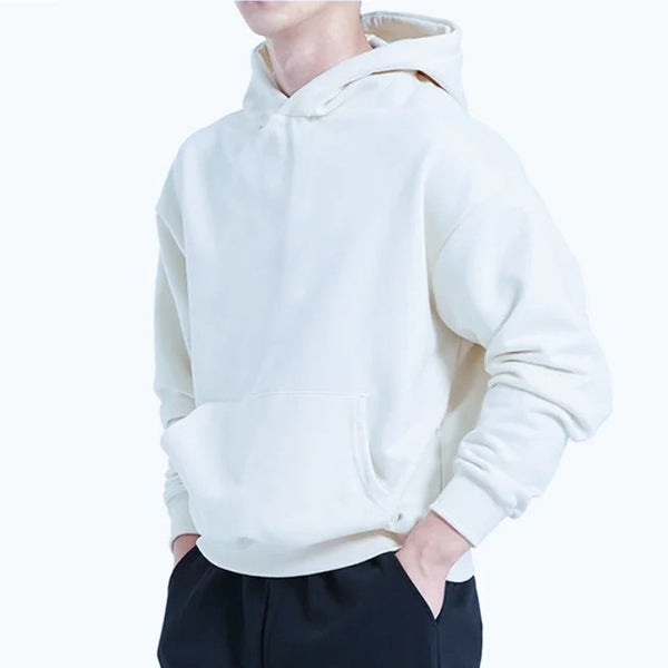 Person wearing a white hoodie and dark pants on a light gray background