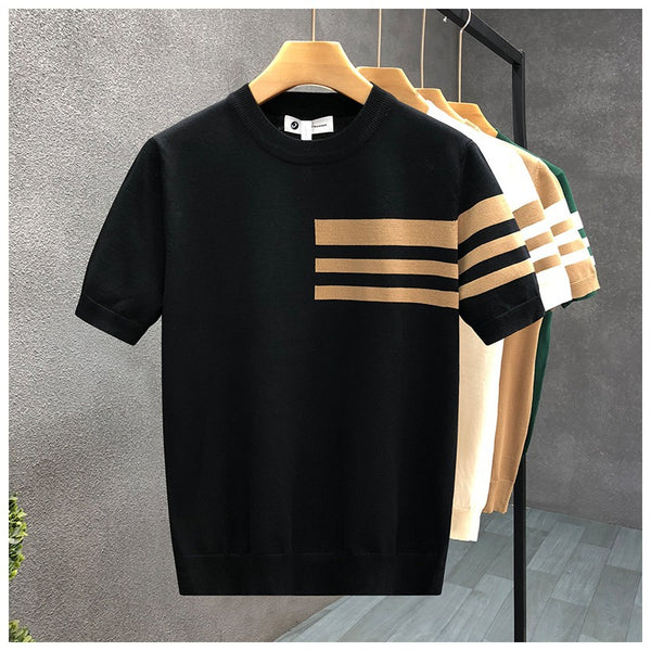 Black t-shirt with beige stripes on a hanger against a gray wall.